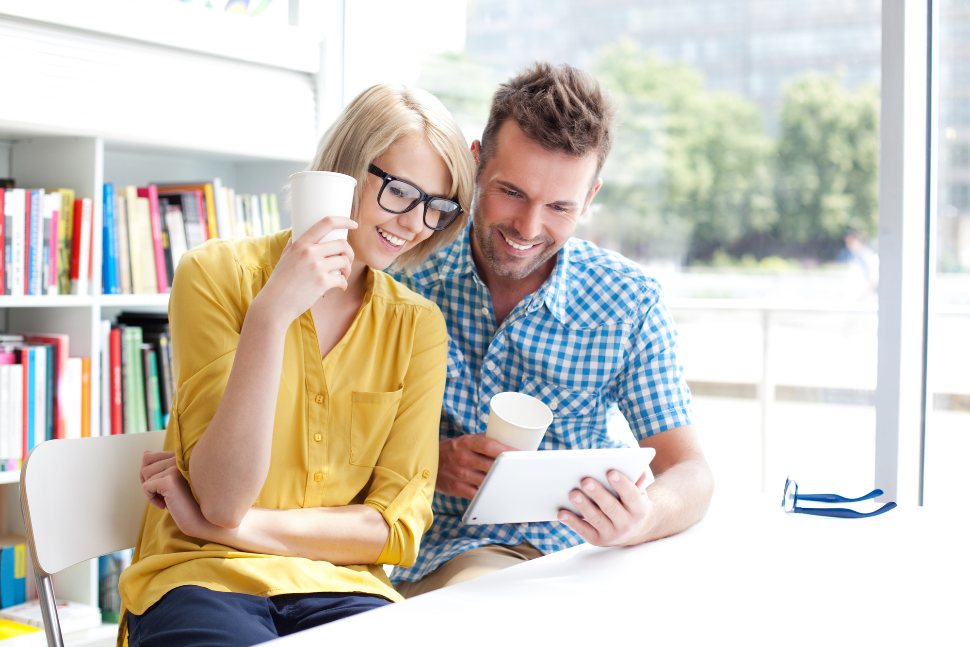 Couple in library working with digital tablet